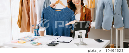 Fashion blogger concept, Young Asian women selling clothes on video streaming.Startup small business SME, using smartphone or tablet taking receive and checking. 104946234