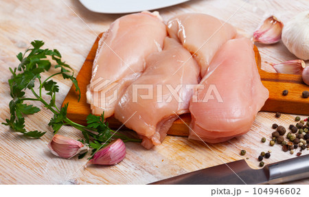 Raw uncooked chicken breast fillet with garlic and greens 104946602