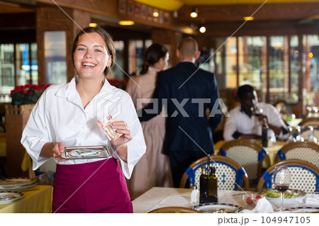 Happy woman waiter with good tip in restaurant 104947105