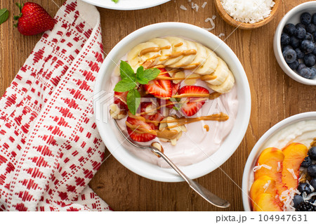 Variety of yogurt bowls with strawberry and plain yogurt 104947631