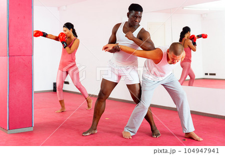 Sparring of two men at self-defense training in sports club Sparring of two men at self-defense training in sports club 104947941