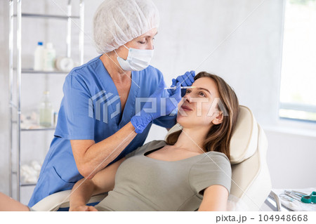 Young patient getting forehead fillers. Young patient getting forehead fillers. 104948668
