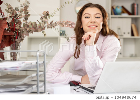 Portrait of positive female secretary in her workplace 104948674