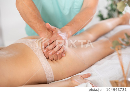 The masseur makes a massage to a woman The masseur makes a massage to a woman 104948721