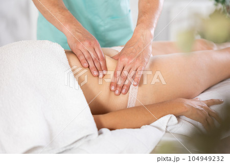 Circumcised hands of male masseur made anti-cellulite massage in abdomen to female client Circumcised hands of male masseur made anti-cellulite massage in abdomen to female client 104949232