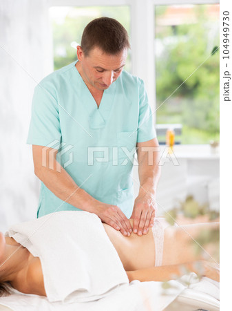 massage therapist doing a body massage 104949730