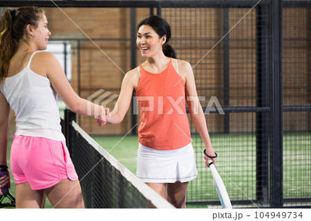 Woman padel player shaking hands to female opponent after match 104949734