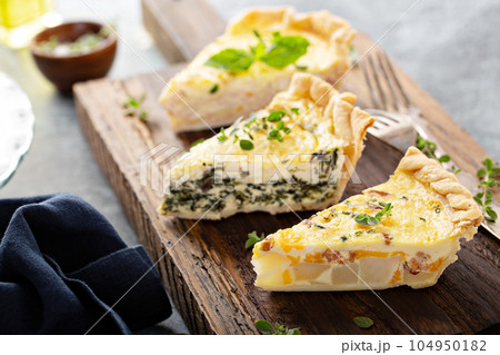 Three quiche pieces on a serving board Three quiche pieces on a serving board 104950182