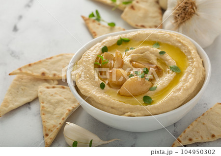 Roasted garlic hummus topped with olive oil 104950302