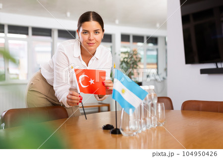 Young lady sets miniatures flags of Argentina and Turkey for international negotiations Young lady sets miniatures flags of Argentina and Turkey for international negotiations 104950426