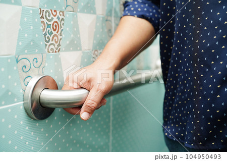 Asian woman patient use toilet support rail in bathroom, handrail safety grab bar, security in nursing hospital. Asian woman patient use toilet support rail in bathroom, handrail safety grab bar, security in nursing hospital. 104950493