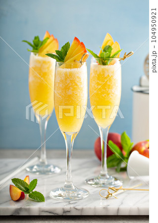 Summertime peach mimosas or bellinis Summertime peach mimosas or bellinis 104950921