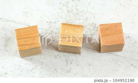 Three blank wooden playing cubes on white board 104952190