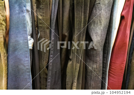 Closeup of old Jeans and trousers displayed at thrift shop Closeup of old Jeans and trousers displayed at thrift shop 104952194