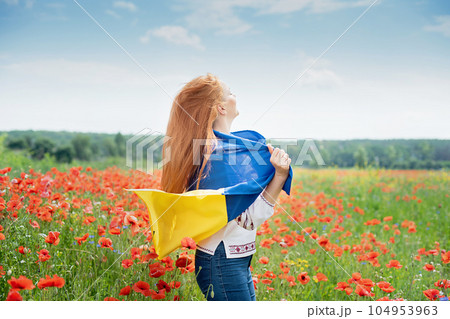 Girl carries fluttering blue and yellow flag of Ukraine in field. Ukraine's Independence Day. Flag Day. Constitution day. Woman in traditional embroidery with flag of Ukraine. 24 August. Patriotic Girl carries fluttering blue and yellow flag of Ukraine in field. Ukraine's Independence Day. Flag Day. Constitution day. Woman in traditional embroidery with flag of Ukraine. 24 August. Patriotic 104953963