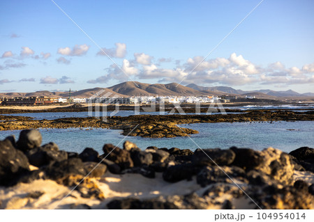 Panoramic view of El Cotillo city in Fuerteventura, Canary Islands, Spain. Scenic colorful traditional villages of Fuerteventura, El Cotillo in northen part of island. Canary islands of Spain. Panoramic view of El Cotillo city in Fuerteventura, Canary Islands, Spain. Scenic colorful traditional villages of Fuerteventura, El Cotillo in northen part of island. Canary islands of Spain. 104954014