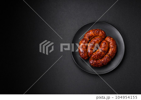 Delicious grilled sausage in the form of a ring with salt, spices and herbs Delicious grilled sausage in the form of a ring with salt, spices and herbs 104954155