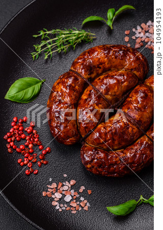 Delicious grilled sausage in the form of a ring with salt, spices and herbs 104954193