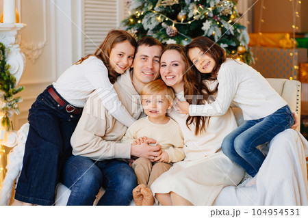 Beautiful happy large family on the couch by the Christmas tree. 104954531