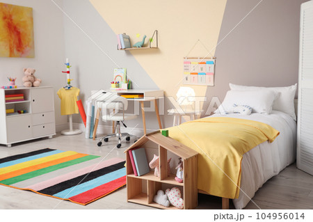 Stylish child room interior with comfortable bed and desk 104956014
