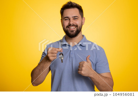 Happy young man real estate agent showing keys of new home house apartment, buying renting property 104956081