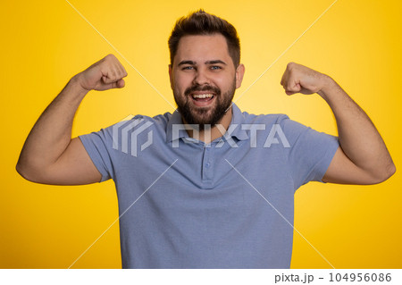 Fit sporty caucasian man showing biceps and looking confident, feeling power strength success win 104956086