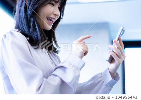 オフィスでスマホを使う女性 オフィスでスマホを使う女性 104956443