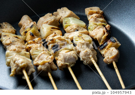 焼鳥(ねぎま串)をフライパンで温め直す調理シーン。 焼鳥(ねぎま串)をフライパンで温め直す調理シーン。 104957943