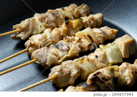 焼鳥(ねぎま串)をフライパンで温め直す調理シーン。 104957945