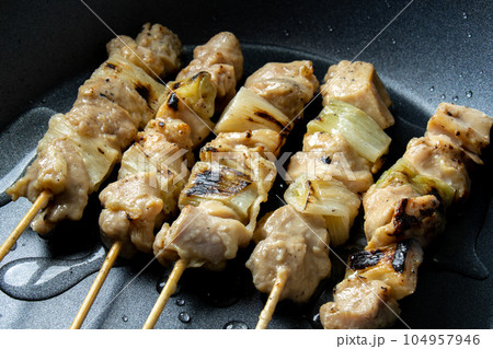 焼鳥(ねぎま串)をフライパンで温め直す(酒をかけて)調理シーン。 焼鳥(ねぎま串)をフライパンで温め直す(酒をかけて)調理シーン。 104957946