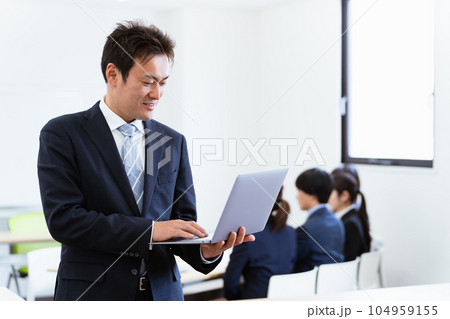 オフィスでパソコンを持つ真面目なアジア人ビジネスマン(中高年男性) オフィスでパソコンを持つ真面目なアジア人ビジネスマン(中高年男性) 104959155