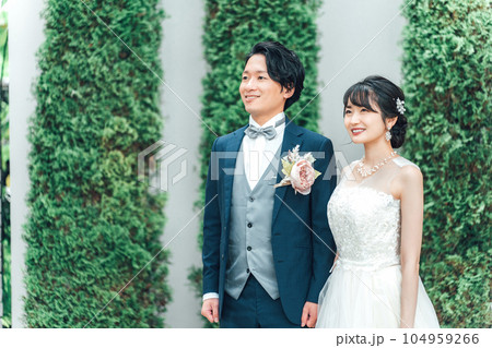 結婚式で結婚式場の庭で腕を組む新郎新婦（ガーデンウェディング）の 