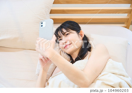 ベッドでスマホを使う女性 ベッドでスマホを使う女性 104960203