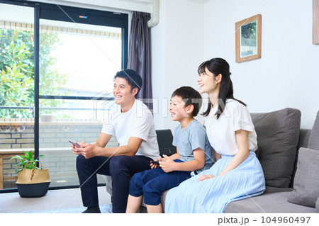 ソファーに座りゲームを楽しむ親子　 104960497