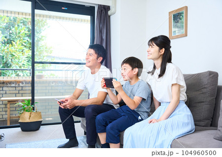 ソファーに座りゲームを楽しむ親子　 104960500