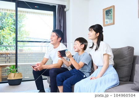 ソファーに座りゲームを楽しむ親子　 104960504