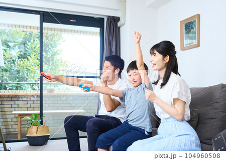 ソファーに座りゲームを楽しむ親子　 104960508