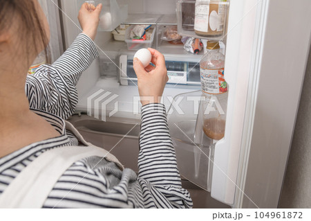 【冷蔵室からたまごを取り出す主婦】 【冷蔵室からたまごを取り出す主婦】 104961872