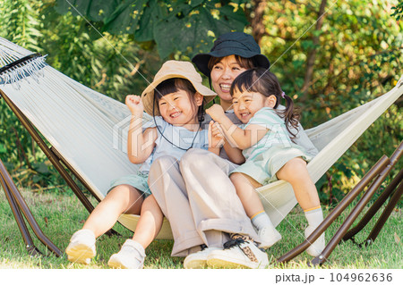 キャンプ場のハンモックで遊ぶ家族・ファミリー（アウトドア・旅行・レジャー・ピクニック） 104962636