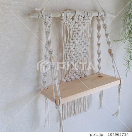壁にかかったマクラメ編みのタペストリーシェルフ 104963754