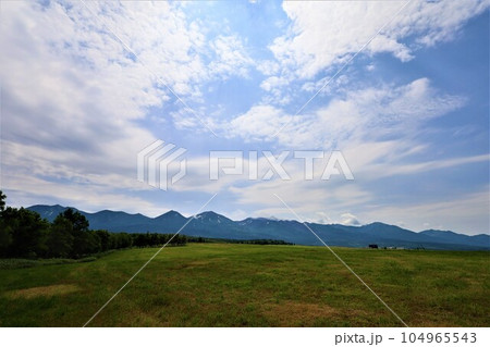 七月の北海道、大雪山国立公園の懐に抱かれて十勝岳、富良野岳、美瑛岳、美瑛富士と連山を望む初夏の北海道 104965543