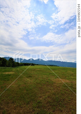 七月の北海道、大雪山国立公園の懐に抱かれて十勝岳、富良野岳、美瑛岳、美瑛富士と連山を望む初夏の北海道 104965544