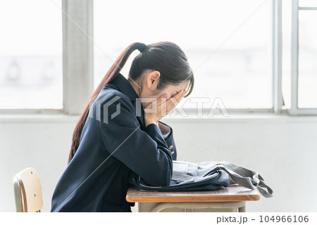 学校の教室で女子高校生・中学生が俯いて悩んでいる(悩む・困る・ストレス) 学校の教室で女子高校生・中学生が俯いて悩んでいる(悩む・困る・ストレス) 104966106