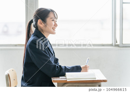 学校の教室で数学の教科書・参考書を見ながら勉強する女子高校生・中学生の生徒 学校の教室で数学の教科書・参考書を見ながら勉強する女子高校生・中学生の生徒 104966615