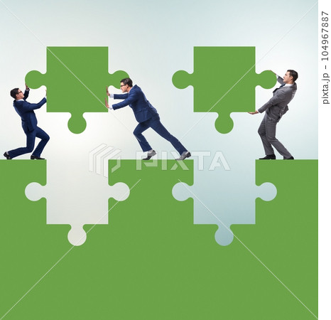 Businessman in teamwork concept with jigsaw puzzle Businessman in teamwork concept with jigsaw puzzle 104967887