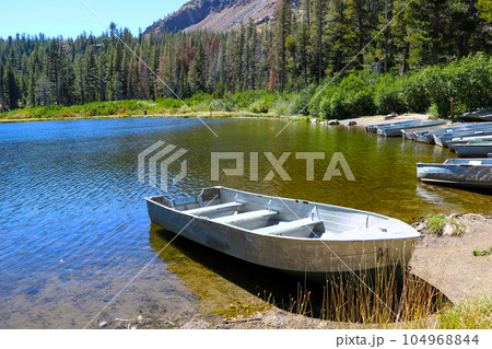 Moored small boats on the shore of a lake in the USA. Moored small boats on the shore of a lake in the USA. 104968844