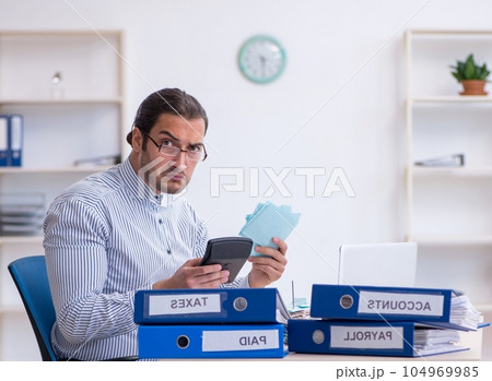 Young male bookkeeper calculating tax payments in the office 104969985