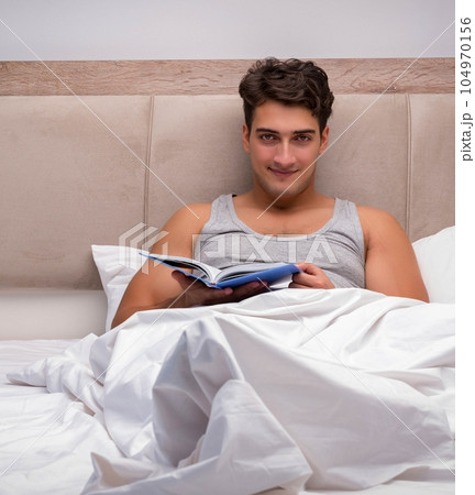 Man reading book in the bed Man reading book in the bed 104970156