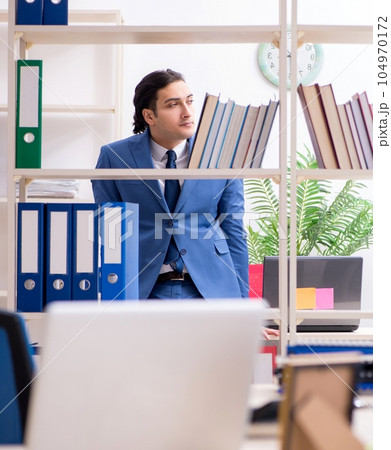 Young handsome employee in the office Young handsome employee in the office 104970172