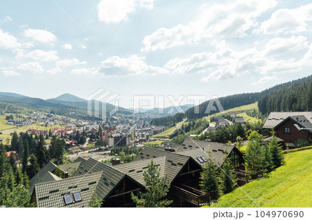 A review view of the resort city in the Carpathian mountains. Roofs of houses and mountains look very atmospheric A review view of the resort city in the Carpathian mountains. Roofs of houses and mountains look very atmospheric 104970690